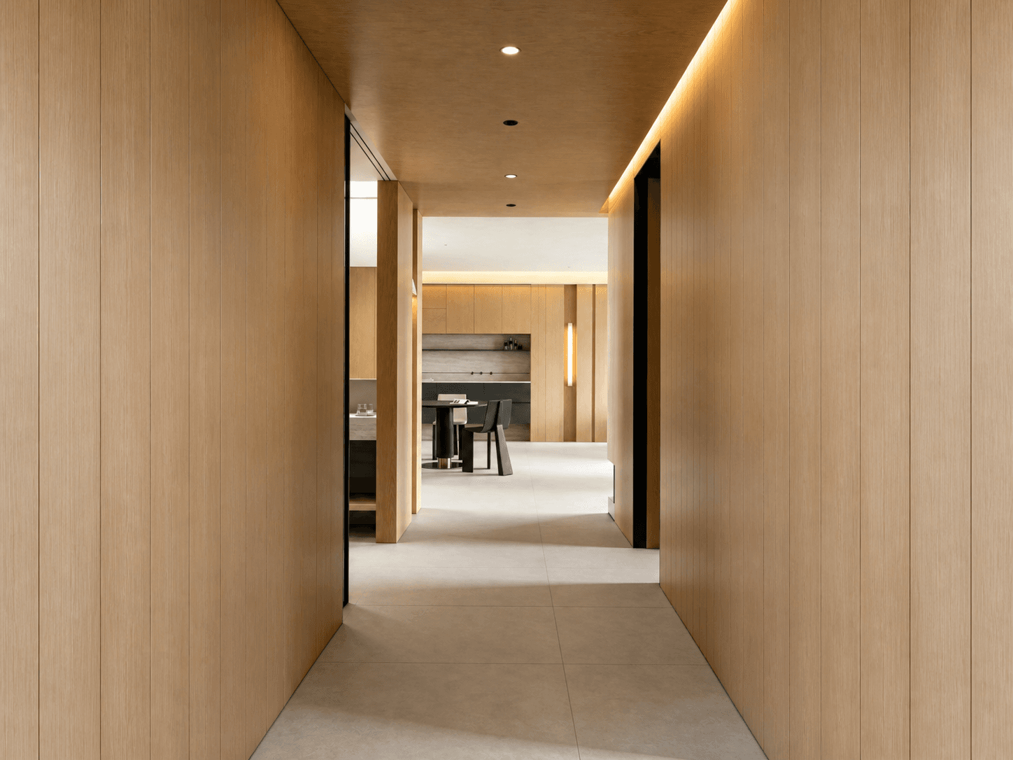 Full-height timber cabinetry and softly lit corridor connecting the home